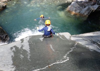 Enfant réalisant un toboggan naturel dans le canyon de Eau Rousse en Savoie